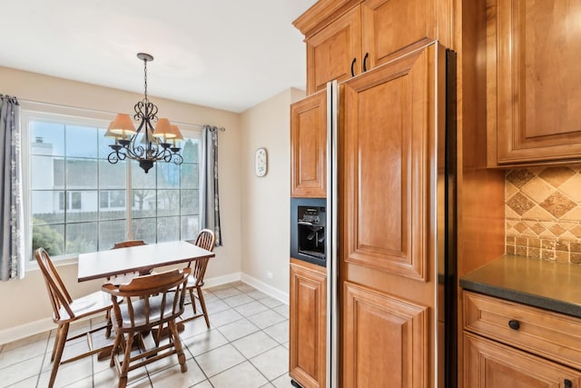 kitchen featuring light tile patterned floors, paneled built in fridge, decorative backsplash, decorative light fixtures, and a chandelier