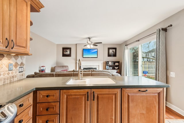 kitchen with sink, tasteful backsplash, ceiling fan, light hardwood / wood-style floors, and stove