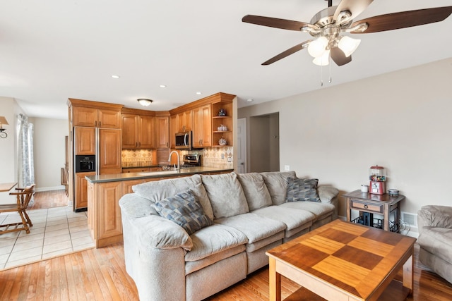 living room with ceiling fan and light wood-type flooring