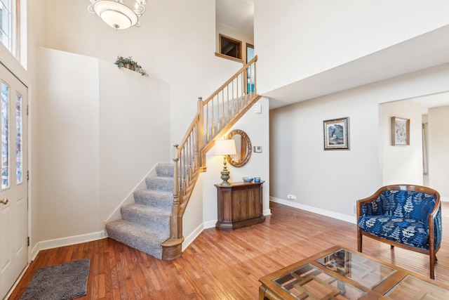 foyer featuring hardwood / wood-style flooring and a towering ceiling