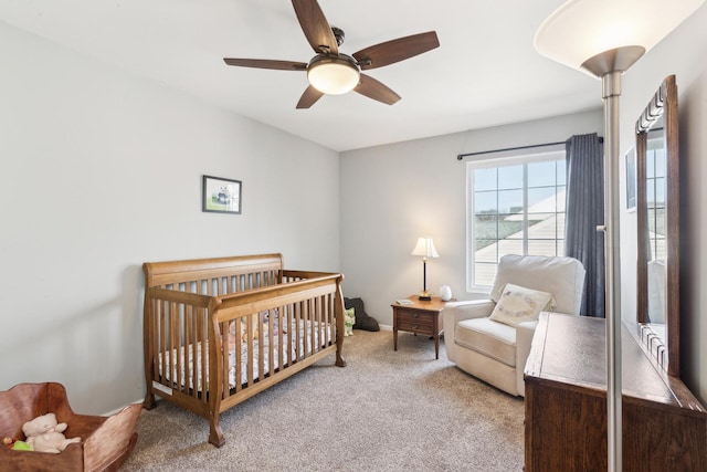 carpeted bedroom with a nursery area and ceiling fan