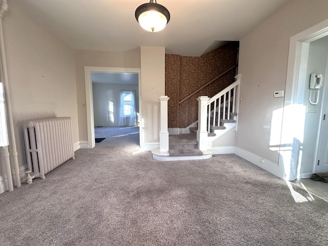 unfurnished living room featuring carpet and radiator heating unit