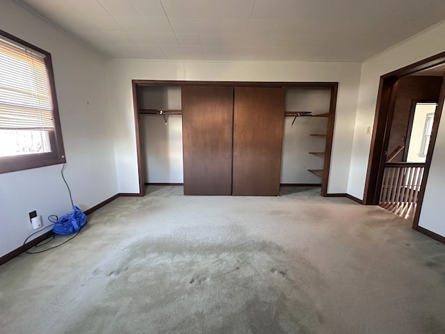 unfurnished bedroom featuring light colored carpet and a closet