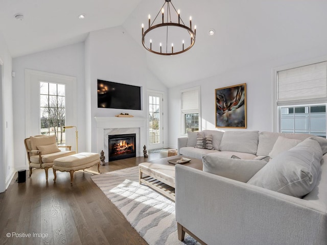 living room with high vaulted ceiling, a healthy amount of sunlight, dark hardwood / wood-style floors, and a premium fireplace