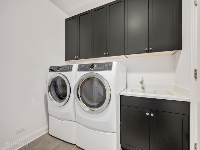 washroom featuring cabinets, sink, and washing machine and clothes dryer