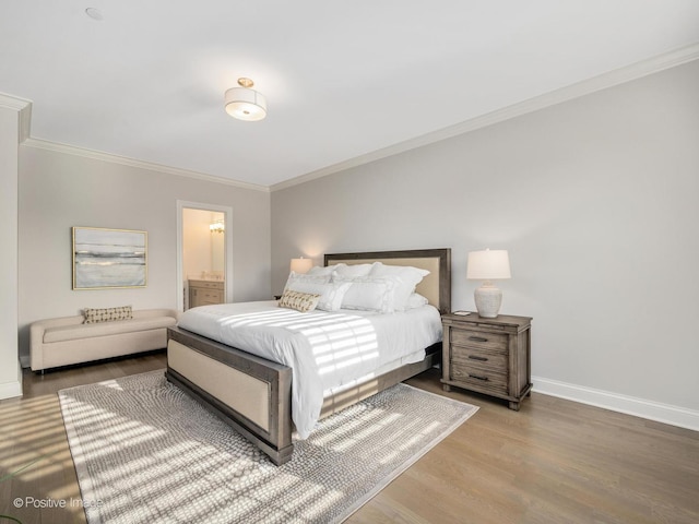 bedroom featuring hardwood / wood-style flooring, ensuite bathroom, and crown molding