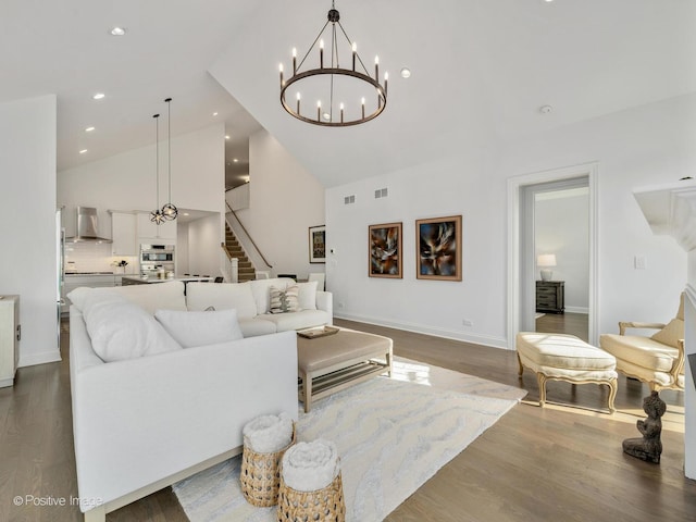 living room with hardwood / wood-style flooring, high vaulted ceiling, and a chandelier