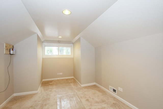 bonus room with light carpet and vaulted ceiling