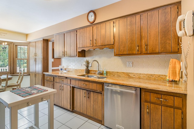 kitchen with tasteful backsplash, sink, light tile patterned flooring, and stainless steel dishwasher