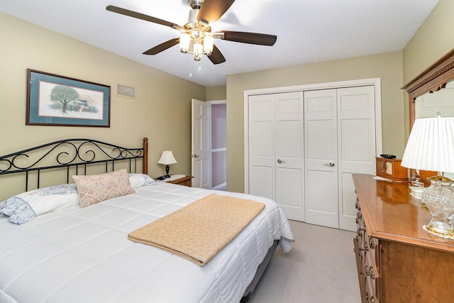 bedroom featuring ceiling fan, light colored carpet, and a closet