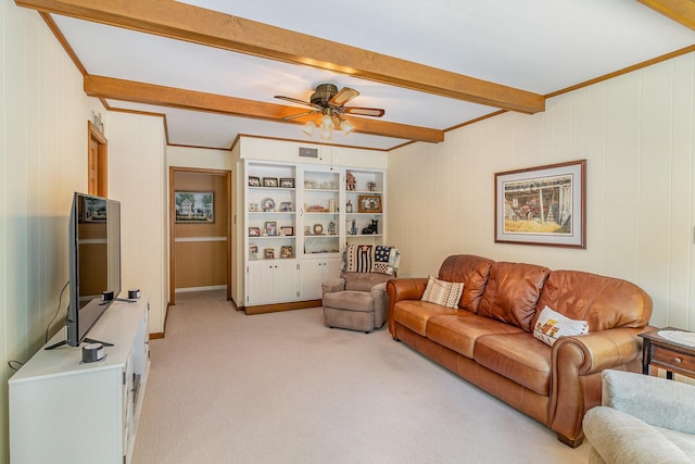 living room with beam ceiling, ceiling fan, built in features, crown molding, and light colored carpet