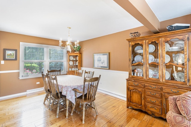 dining room featuring beamed ceiling, an inviting chandelier, light wood-type flooring, and a baseboard radiator