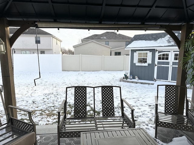 snow covered patio featuring a shed