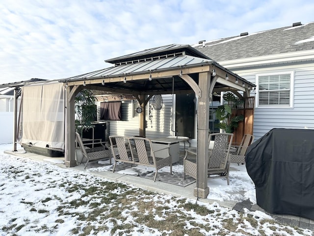 snow covered patio featuring a gazebo and area for grilling