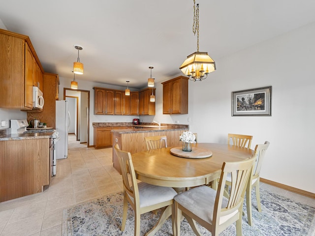 dining area featuring a notable chandelier and light tile patterned flooring