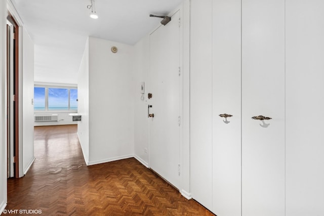 corridor with dark parquet floors and a wall mounted AC