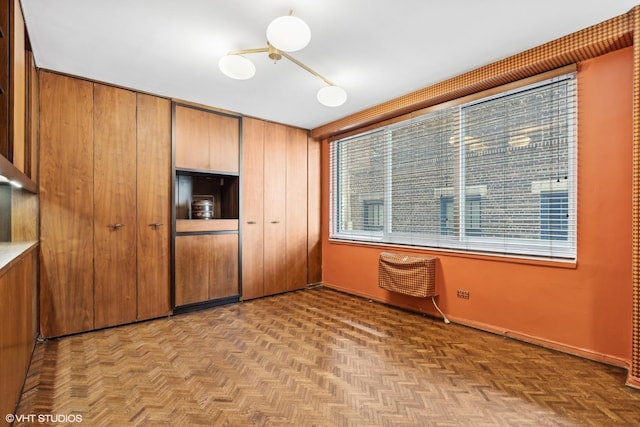 unfurnished bedroom with multiple windows, light parquet flooring, and a closet