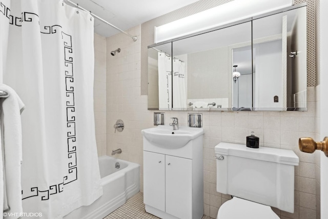 full bathroom with vanity, tile walls, shower / tub combo with curtain, and toilet