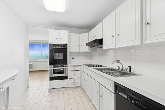 kitchen featuring white cabinetry, backsplash, sink, and black appliances