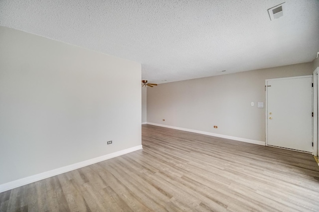 empty room with light hardwood / wood-style flooring and a textured ceiling