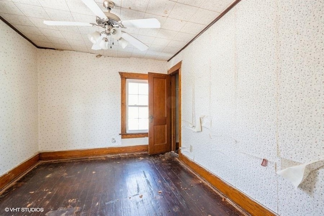 empty room featuring ceiling fan, dark hardwood / wood-style flooring, and crown molding