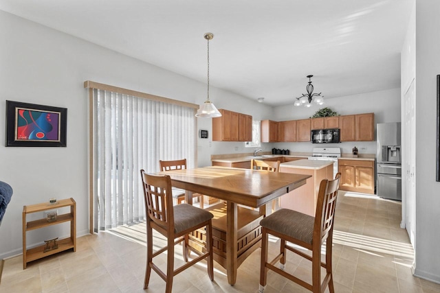 dining space with sink, a notable chandelier, and light tile patterned flooring