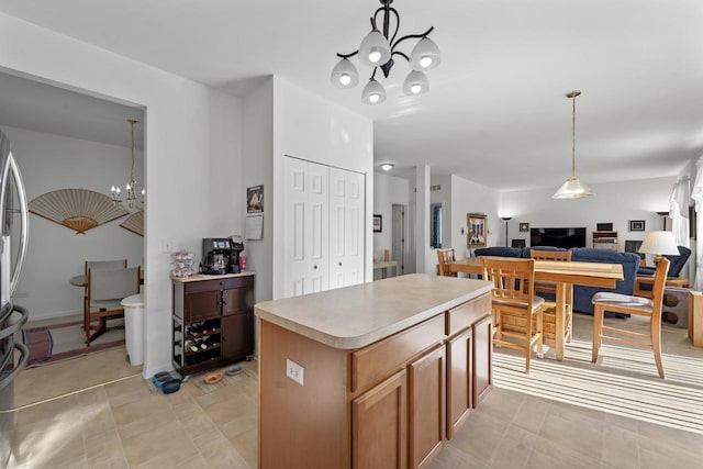 kitchen with an inviting chandelier, a kitchen island, and pendant lighting