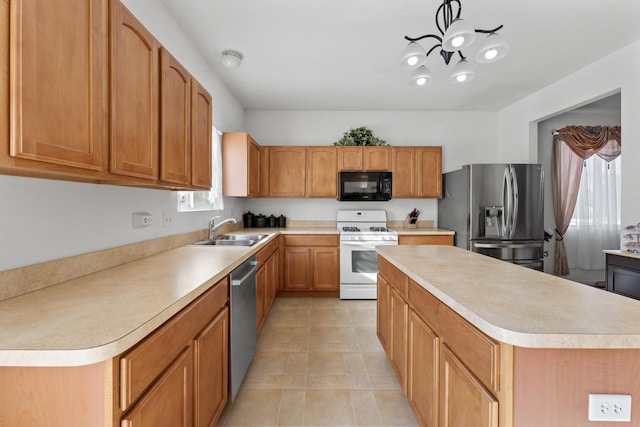 kitchen featuring ceiling fan, sink, stainless steel appliances, and a kitchen island