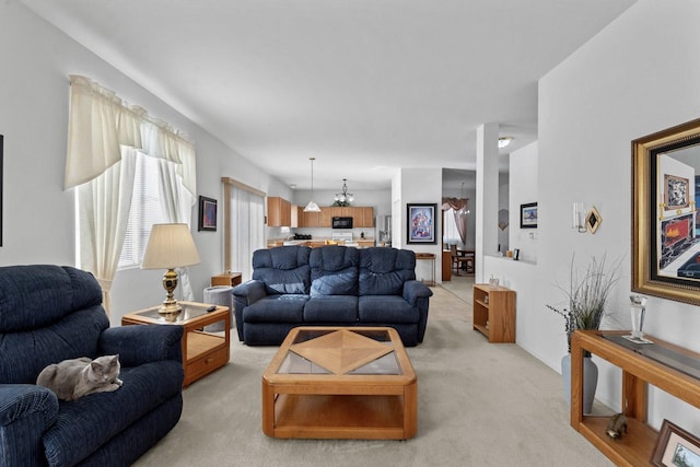 living room featuring light colored carpet and a chandelier