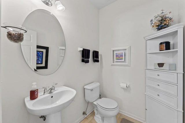 bathroom featuring sink, toilet, and tile patterned flooring