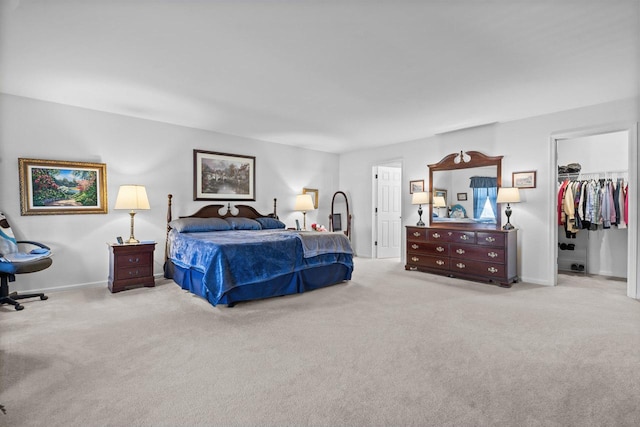 bedroom with a spacious closet, a closet, and light colored carpet