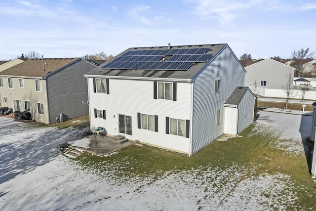 rear view of property with solar panels