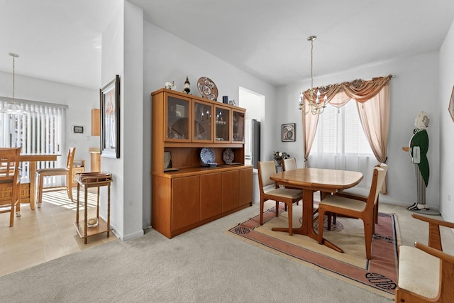 dining area featuring light carpet, a notable chandelier, and a wealth of natural light