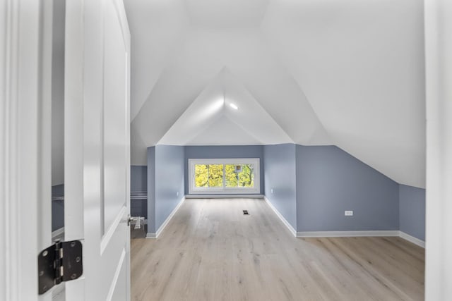 bonus room featuring light hardwood / wood-style floors and vaulted ceiling