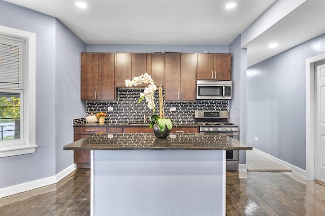 kitchen with dark wood-type flooring, decorative backsplash, a center island, and stainless steel appliances