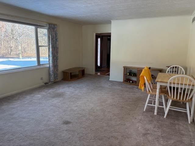 unfurnished dining area with a textured ceiling and carpet