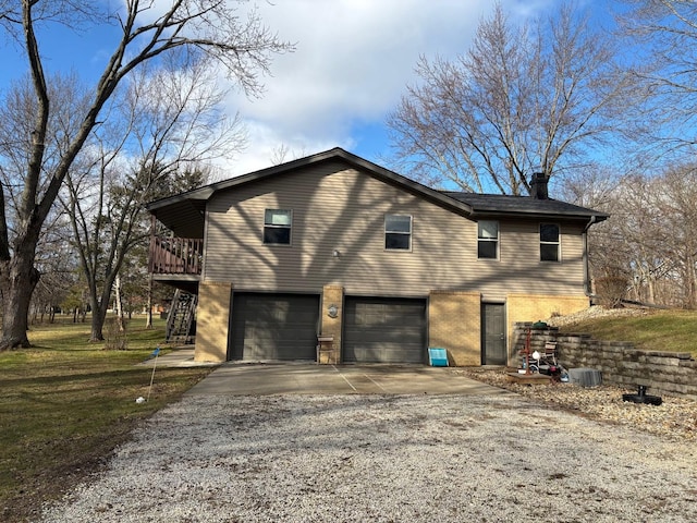 view of side of property featuring a garage, a wooden deck, and a yard