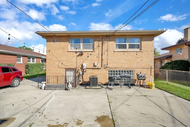 rear view of house with central air condition unit and a patio