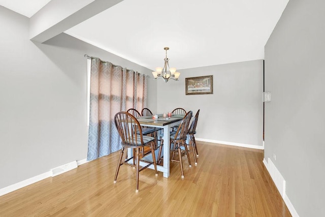 dining room featuring a notable chandelier and light hardwood / wood-style flooring