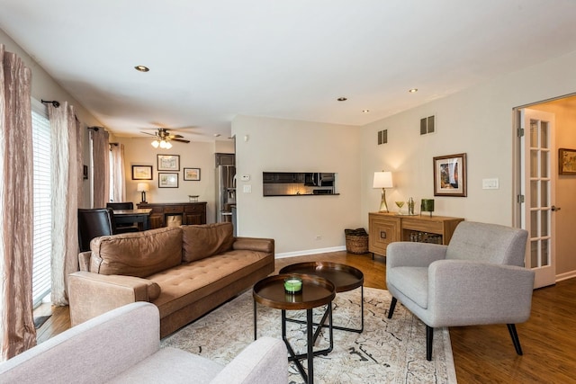 living area featuring wood finished floors, visible vents, and baseboards