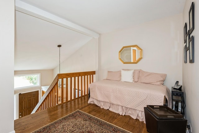 bedroom featuring lofted ceiling with beams and wood finished floors