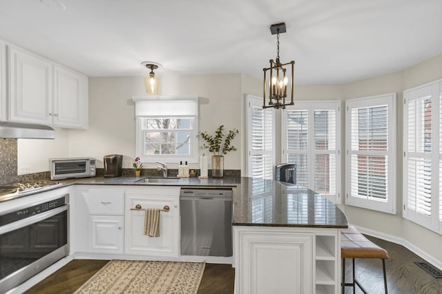 kitchen with kitchen peninsula, stainless steel appliances, white cabinetry, and sink