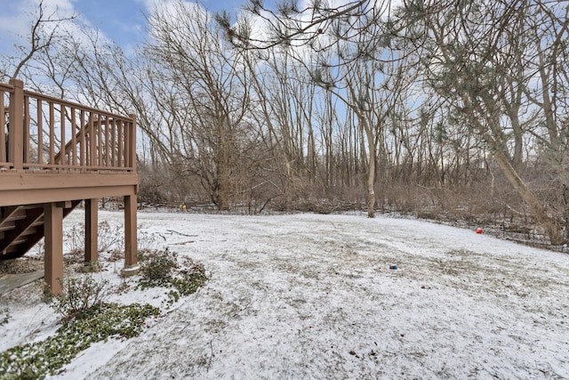 yard covered in snow with a wooden deck