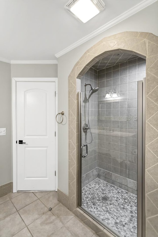 bathroom featuring tile patterned floors, a shower with door, and ornamental molding