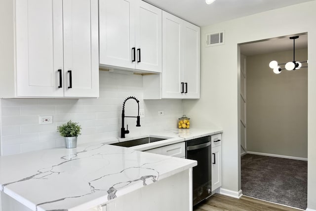 kitchen with dishwasher, light stone countertops, white cabinetry, and hanging light fixtures