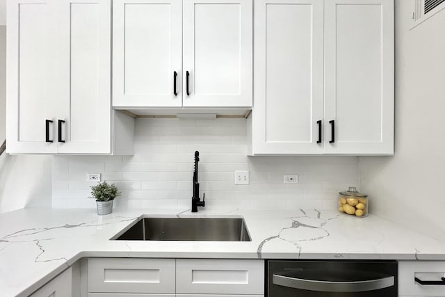 kitchen featuring white cabinets, backsplash, dishwasher, and sink