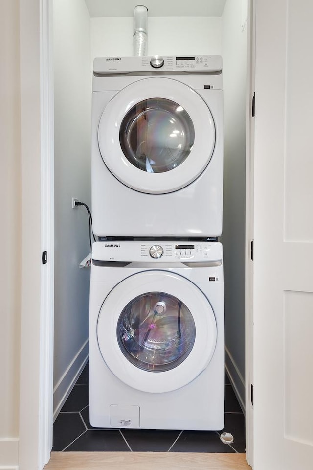 laundry area with tile patterned floors and stacked washer / drying machine