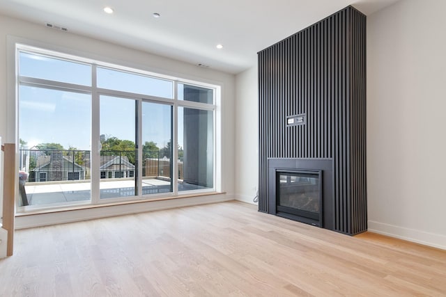 unfurnished living room with light wood-type flooring and plenty of natural light