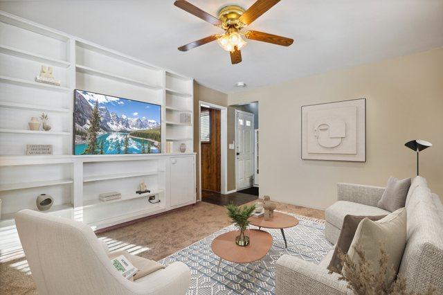 carpeted living room with ceiling fan