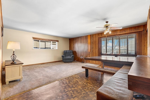 living room featuring wood walls and ceiling fan